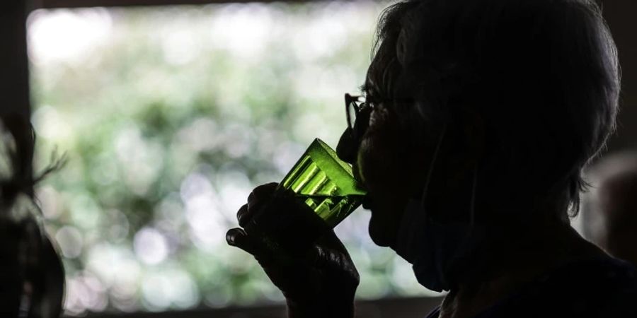 Ältere Frau mit einem Glas Wasser