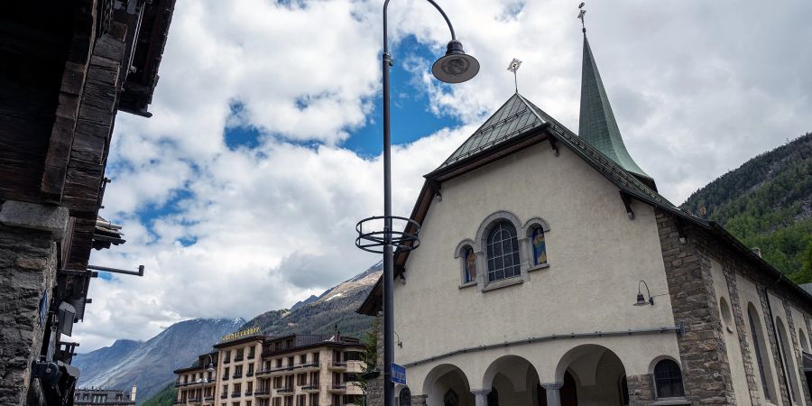 Die katholische Kirche in Zermatt. Links das Grand Hotel Zermatterhof.