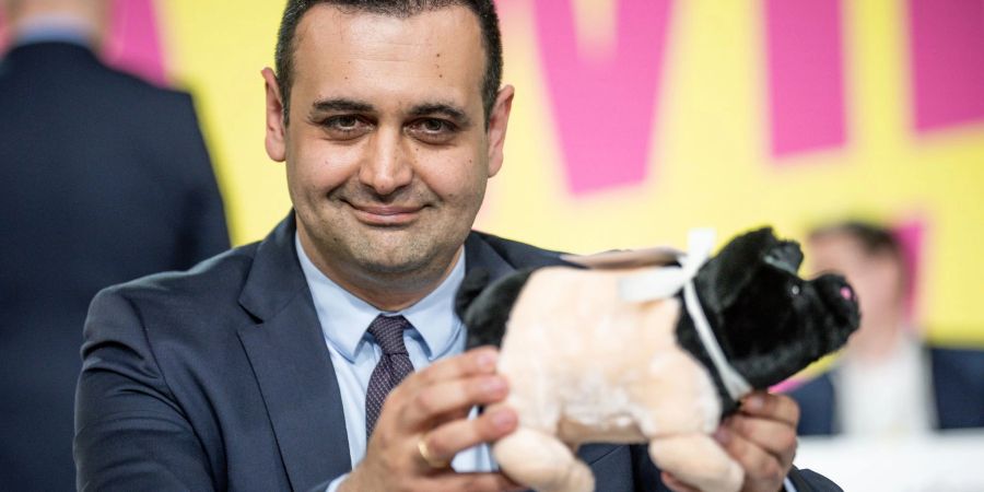 Der neugewählte FDP-Generalsekretär Bijan Djir-Sarai präsentiert ein geschenktes Glücksschwein.
