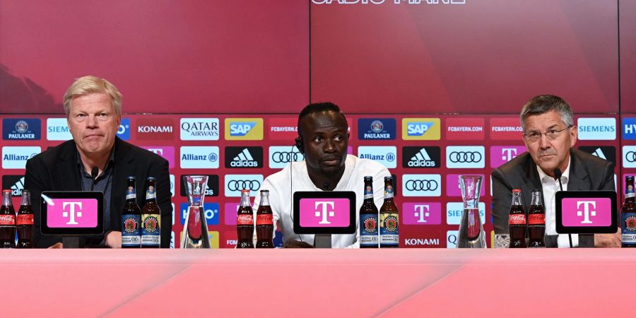 Sadio Mané (M) sitzt während seiner Vorstellung neben dem Vorstandsvorsitzenden Oliver Kahn (l) auf dem Podium.