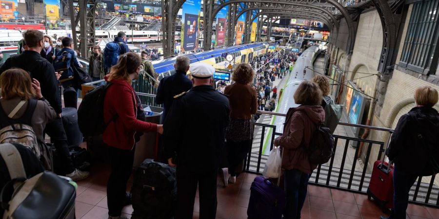 Reisende warten im Hamburger Hauptbahnhof auf ihre Züge. Wegen eines Kabelbrandes kommt es im Fernverkehr zu starken Beeinträchtigungen.