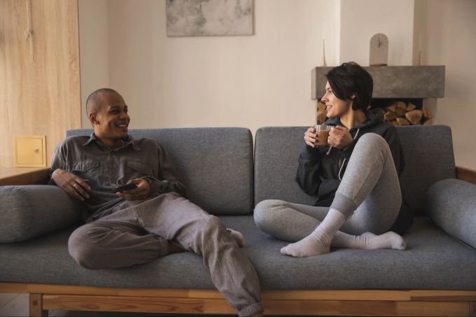 Für ein Gespräch sollte man sich als Paar bewusst Zeit nehmen. Paar auf Sofa