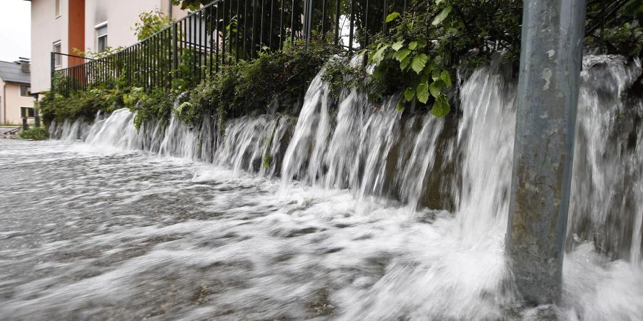 Wasser strömt auf eine Strasse in Viktring bei Klagenfurt in Kärnten.