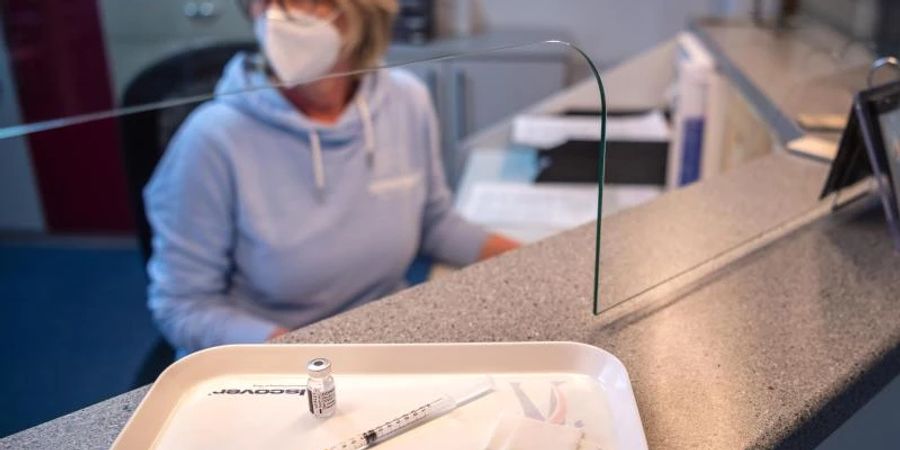 Eine Spritze mit dem Impfstoff von Biontech/Pfizer am Empfang einer Arztpraxis. Foto: Sina Schuldt/dpa