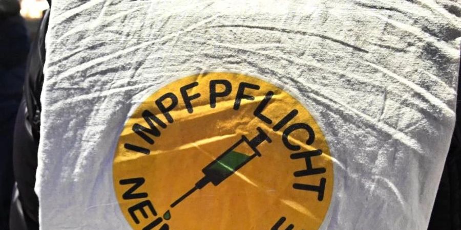 Impflicht, ja oder nein? Dieser Demonstrant hat eine klare Meinung zu dem Thema. Foto: Bernd Weissbrod/dpa
