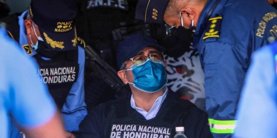 Juan Orlando Hernandez (M), Ex-Präsident von Honduras, spricht mit Polizeibeamten nach seiner Festnahme in seinem Haus. Foto: Indi Ocon/dpa