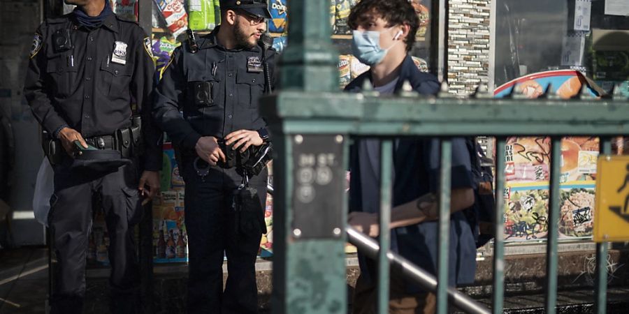 Polizeibeamte bewachen den Eingang der U-Bahn-Station. Foto: John Minchillo/AP/dpa