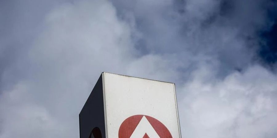 Wolken ziehen über ein Schild der Agentur für Arbeit und dem Berlin-Lichtenberg. Foto: Carsten Koall/dpa