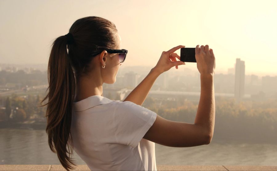 Frau mit Smartphone bei Fotoaufnahme