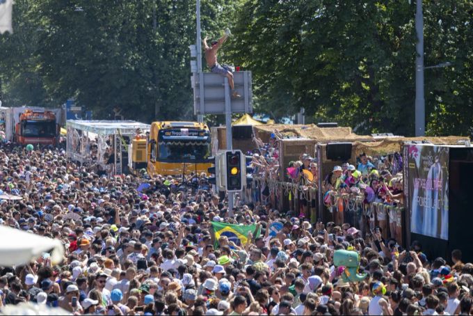 Raver klettert bei der Street Parade auf Verkehrstafel. Street Parade