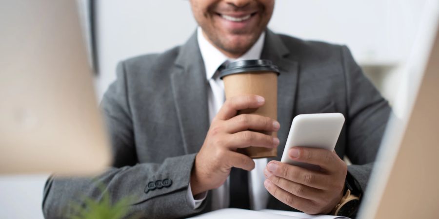 Geschäftsmann mit Handy und Laptop