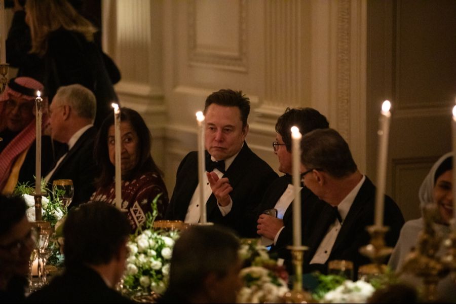 Tech-Mogul Elon Musk diskutiert am Tisch.