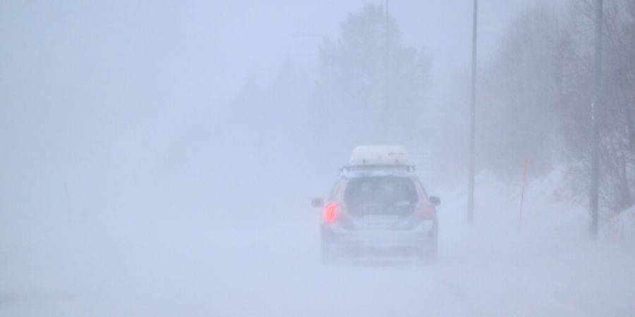 Ein Auto fährt bei Nebel durch eine Schneelandschaft. Sturm Johannes fegt durch Skandinavien. Foto: Pontus Lundahl/TT News Agency/AP/dpa