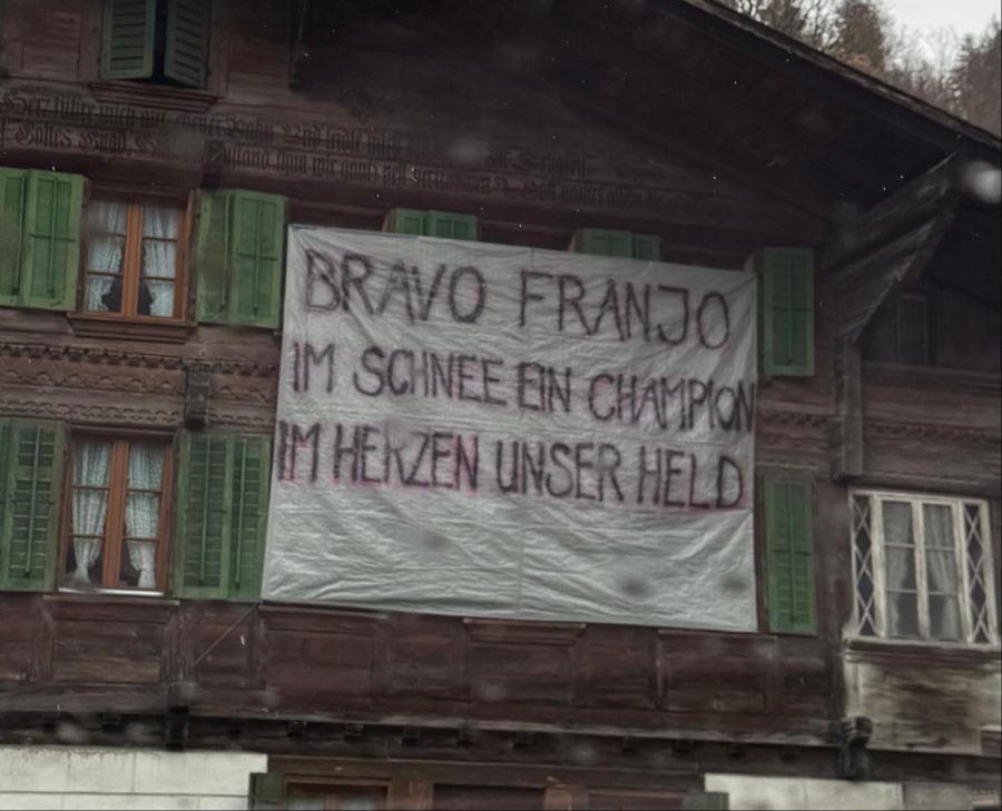 An vielen Häusern und Scheunen hängen Gratulations-Transparente.