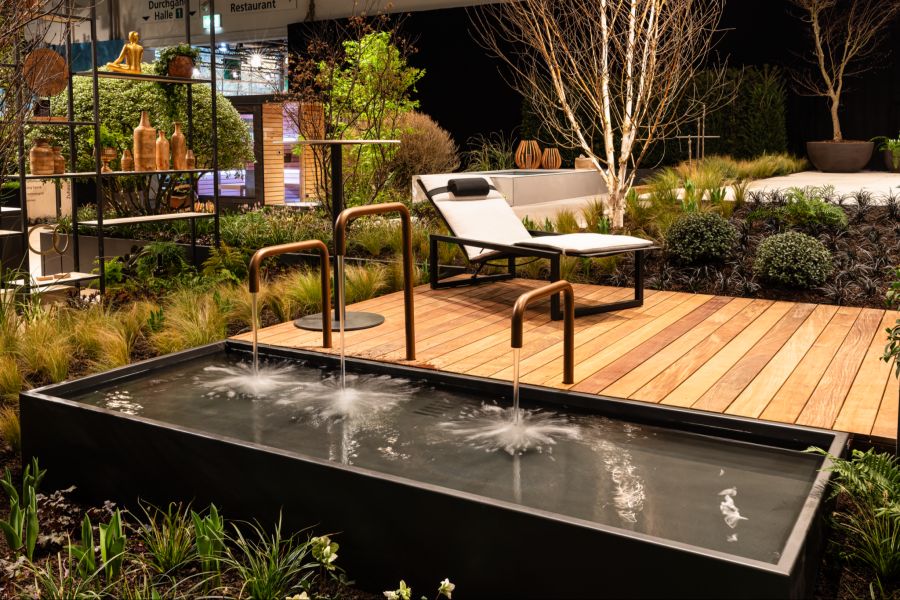 Plätschernder Brunnen, bequemer Liegestuhl, umgeben von üppigem Grün: So könnte ein Wunschgarten aussehen.