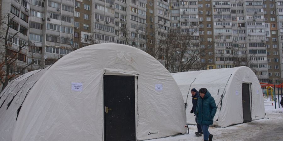 Anwohner gehen an einem der Zelte in Kiew vorbei, die der Katastrophenschutz nach den russischen Luftangriffen auf den ukrainischen Energiesektor aufgestellt hat. Foto: Efrem Lukatsky/A...