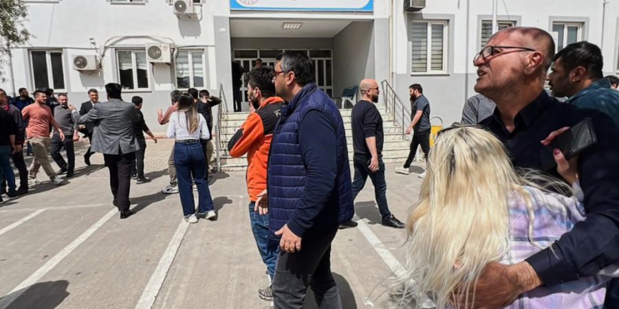 Menschen stehen auf dem Hof eines Gymnasiums in der Türkei, in dem ein Achtklässler das Feuer eröffnet hat. Foto: IHA/IHA via AP/dpa