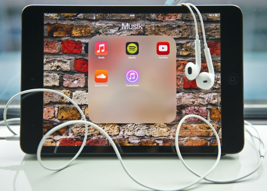 Kommunikation: Ein iPad mit Kopfhörern und geöffnetem App-Ordner.