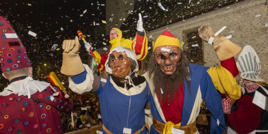 Der Fritschi und die Fritschene geniessen den «Fötzeliräge» nach dem Urknall auf dem Kapellplatz an der Fritschi-Tagwache der Luzerner Fasnacht.