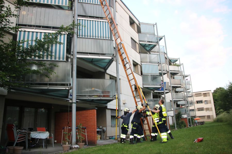 Mithilfe einer Holzleiter verschafft sich die Feuerwehr Rümlang
Zugang zum Balkon eines Gebäudes.