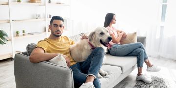 Paar auf Sofa im Streit, Hund