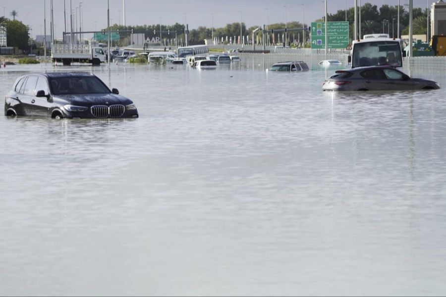 Autos in den Vereinigten Arabischen Emiraten schwimmen durch die Regenfluten.