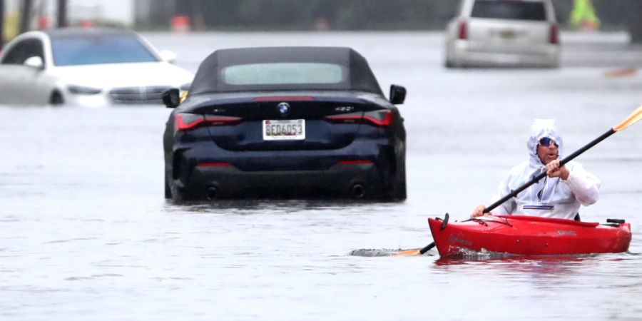 Ted Friedli paddelt während mit seinem Kajak durch einen überfluteten Abschnitt der Florence Avenue. Foto: Noah K. Murray/AP/dpa