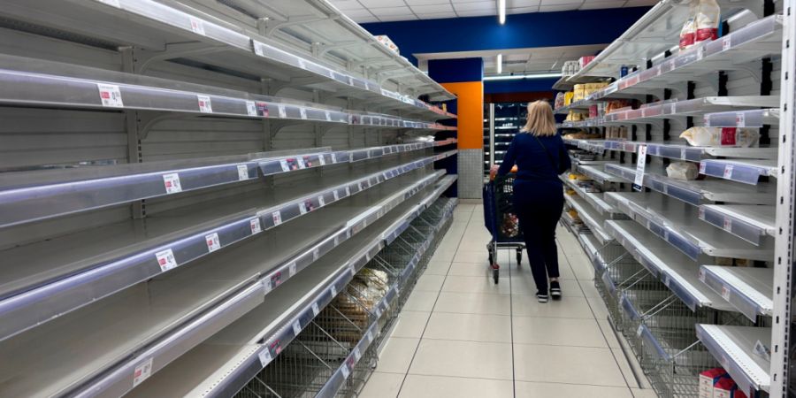 dpatopbilder - Eine Frau geht in einem Supermarkt in Neapel an leeren Regalen vorbei. Foto: Alessandra Tarantino/AP/dpa