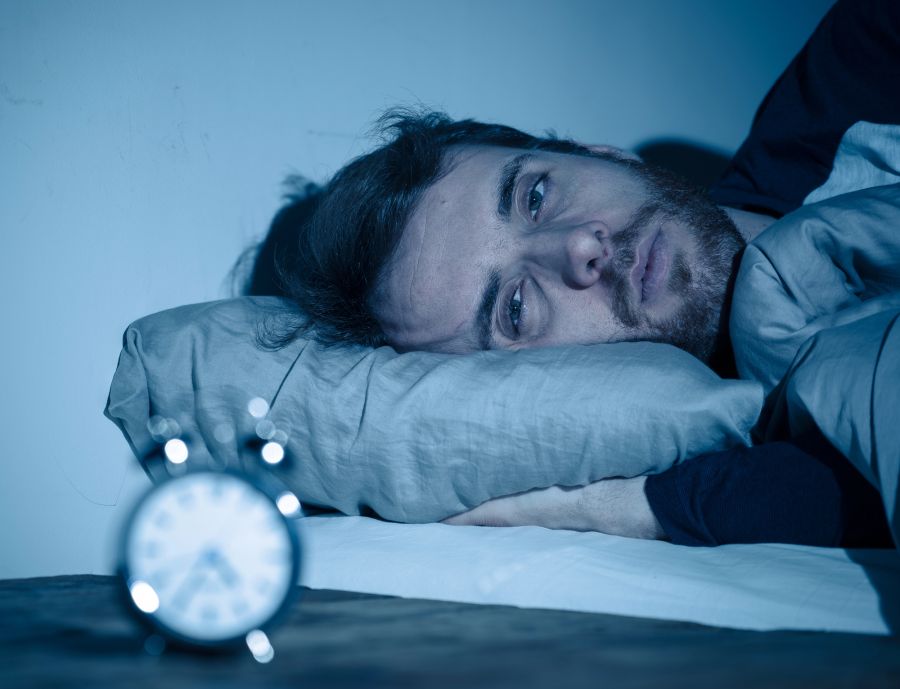 Müder Mann schlaflos im Bett
