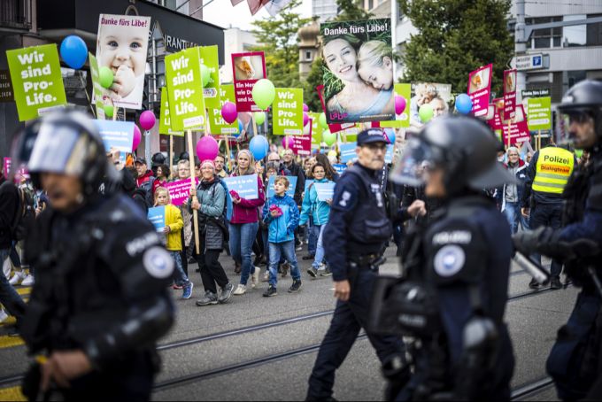 Polizisten sichern die Umzugsroute der Abtreibungsgegner die an der «Marsch fürs Laebe» Kundgebung teilnehmen. Aufgenommen am Samstag, 14. September 2024 in Zuerich Oerlikon. abtreibung marsch fürs läbe