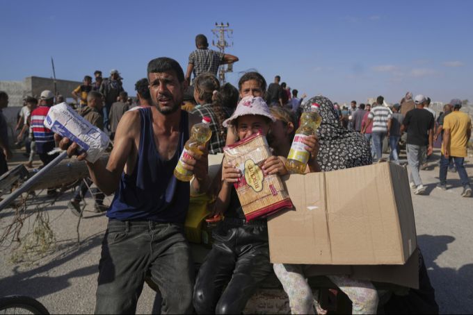 Palästinenser freuen sich über die Lebensmittelhilfe, die sie bei der Verteilstelle erhalten haben. gaza