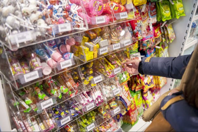 Eine Kundin bedient sich an Süssigkeiten aus einem Regal in einer «k kiosk»-Verkaufsstelle, fotografiert am 7. Januar 2020 am Bahnhof Oerlikon. Süssigkeiten Kiosk
