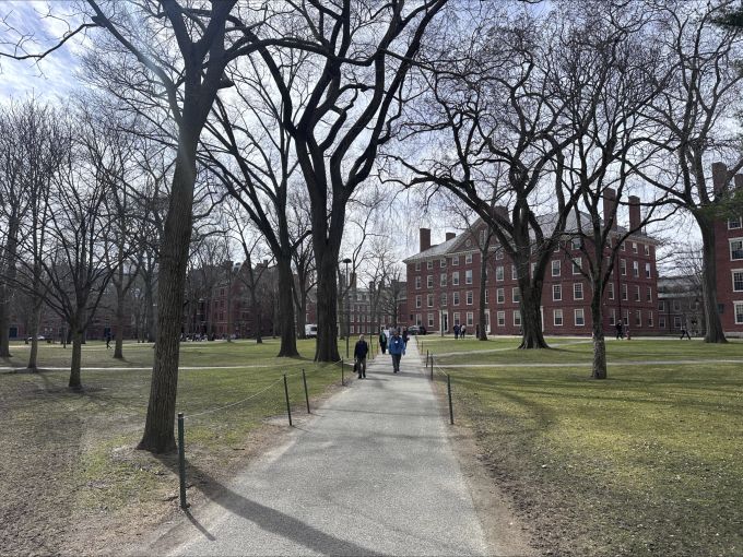 Menschen laufen auf dem Campus der Harvard-Universität. Harvard Free Tuition