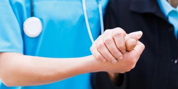 Krankenschwester hält Mann die Hand
