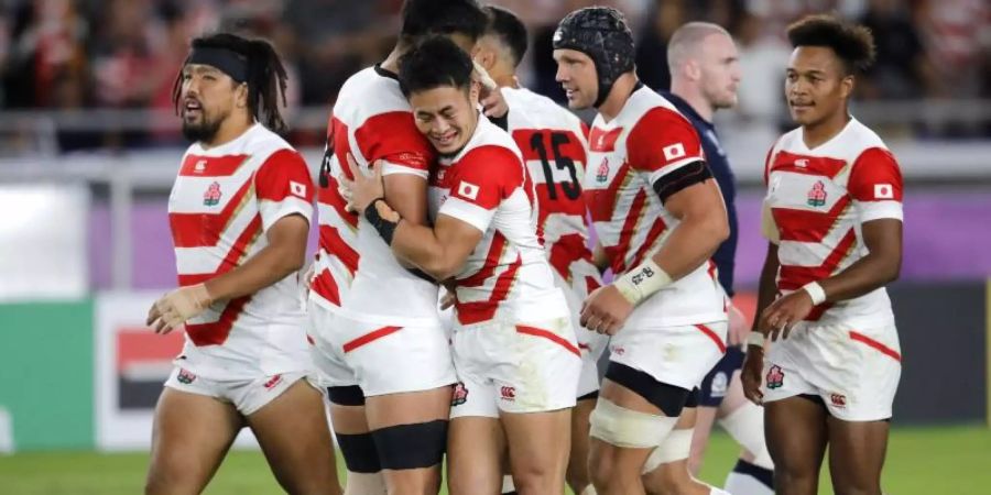 Die Spieler des japanischen Rugby-Teams feiern einen weiteren Versuch gegen Schottland. Foto: Christophe Ena/AP/dpa