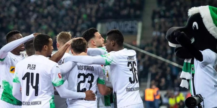 Die Gladbacher Spieler jubeln nach dem Ausgleich zum 1:1 durch Ramy Bensebaini. Foto: Marius Becker/dpa