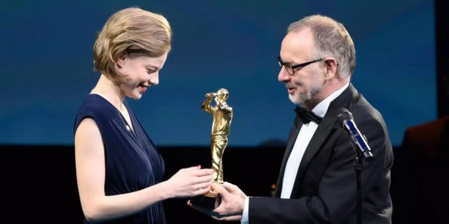 Emma Bading erhält den Preis für die beste Schauspielerin von Manfred Krupp. Foto: Silas Stein/dpa