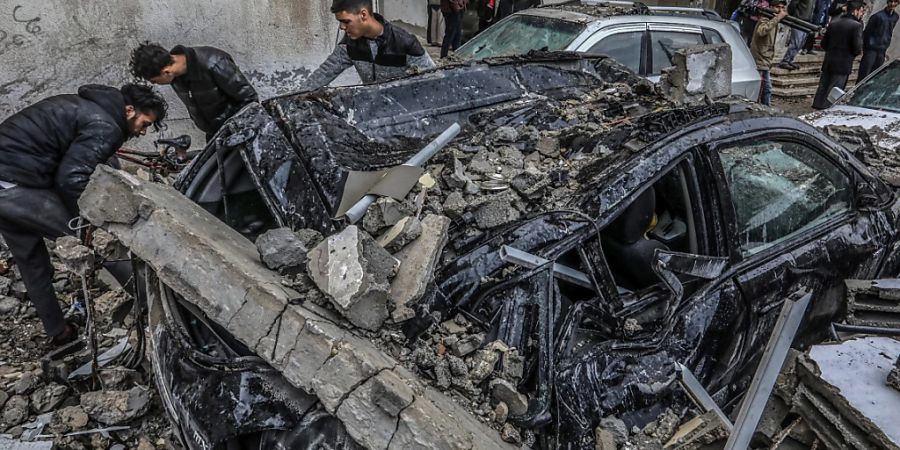 dpatopbilder - Palästinenser inspizieren zerstörte Fahrzeuge nach einem israelischen Luftangriff. Foto: Abed Rahim Khatib/dpa
