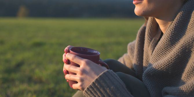 Frau in der Natur mit Tasse