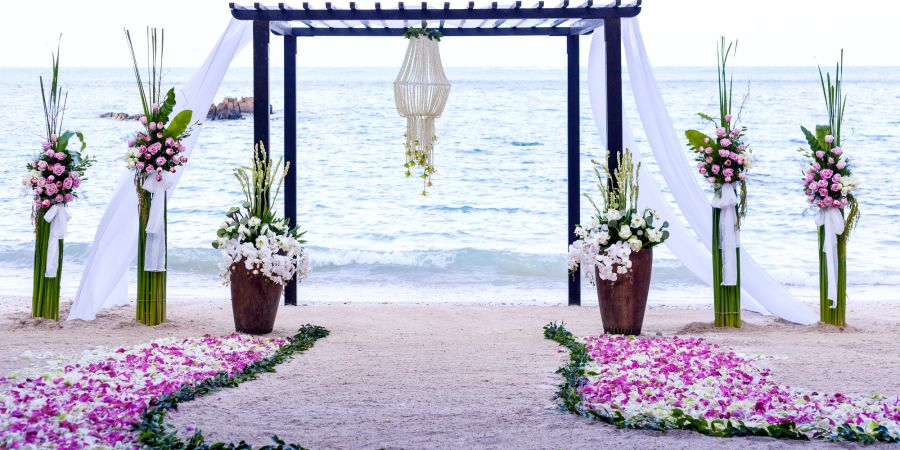 Hochzeits Baldachin am Strand mit Blumen.