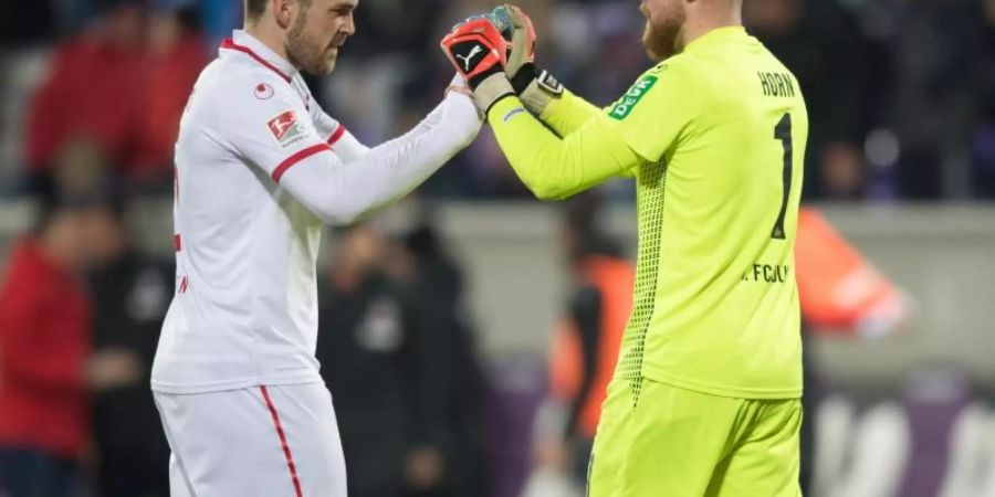 Kölns Rafael Czichos (l) und Torwart Timo Horn feiern den Sieg bei Erzgebirge Aue. Foto: Sebastian Kahnert