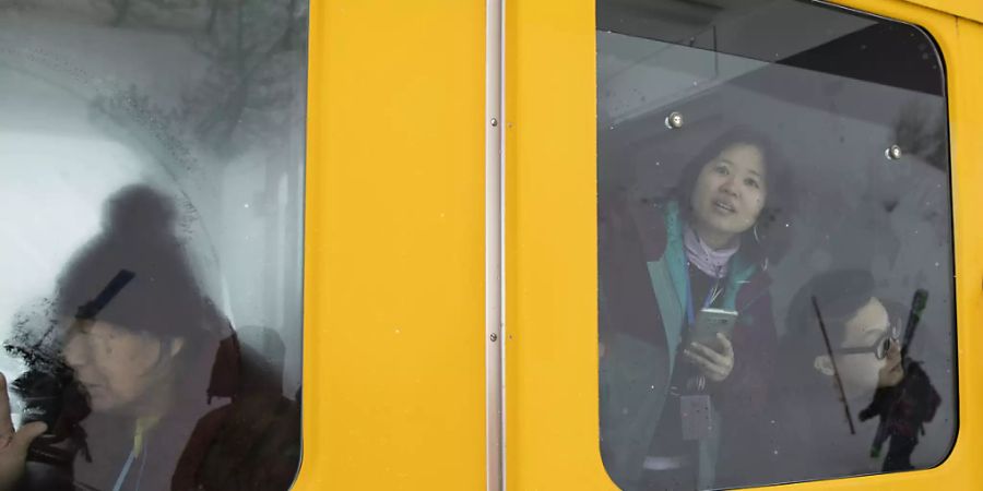 Asiatische Touristen schauen aus einem stillstehenden Zug der Wengernalpbahn im Berner Oberland. Das «Touristen-GA» blieb auch 2018 ein Renner. (Archivbild)
