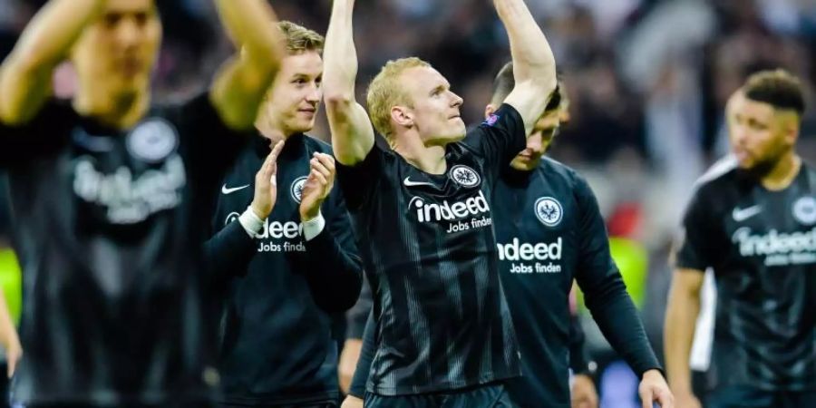 Die Eintracht-Spieler um Torschütze Rode (M) jubeln nach Spielende mit den Fans über das Weiterkommen. Foto: Uwe Anspach