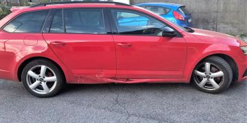 Leicht an der Seite demoliertes, rotes Auto