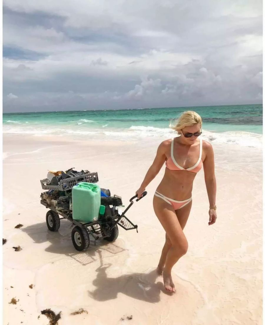 Lindsey Vonn sammelt Abfall am Strand zusammen.