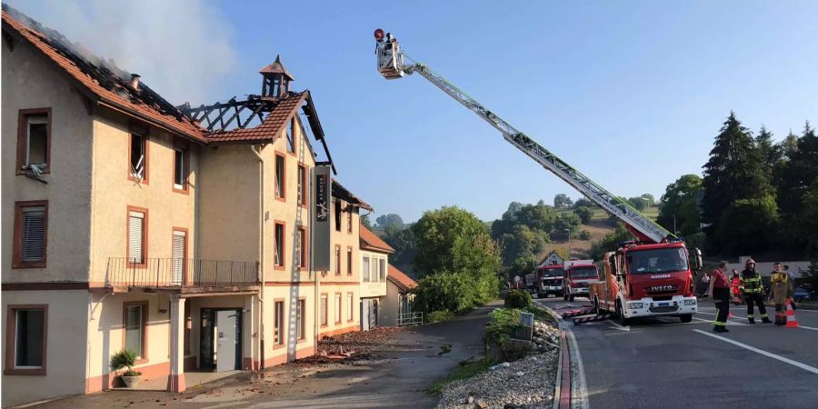 Die Feuerwehr ist auch nach Sonnenaufgang noch mit den Löscharbeiten beschäftigt.