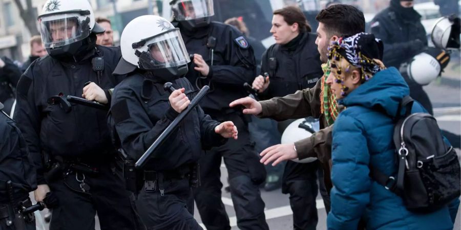 Polizisten drängen Demonstranten zurück.