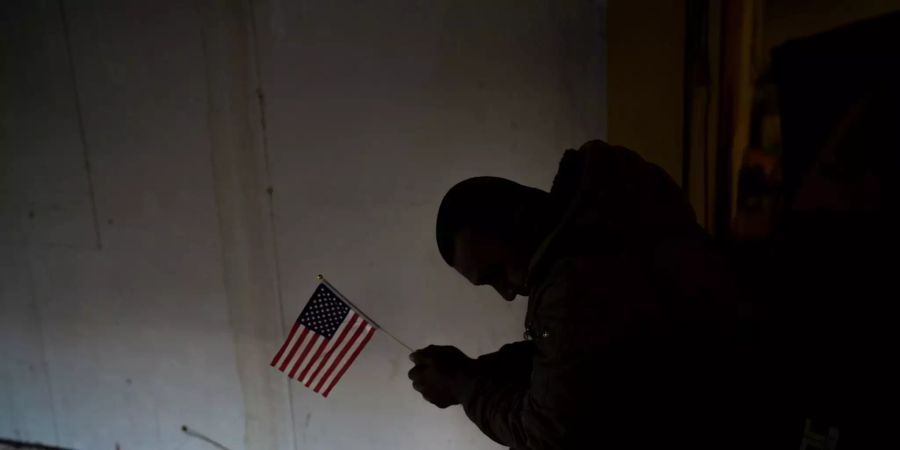 Ein Migrant aus Honduras hält eine US-Flagge.