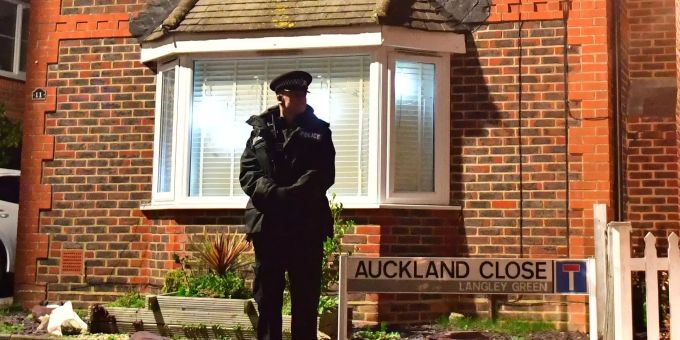 Ein Polizist steht vor einem Haus, das im Zusammenhang mit dem Drohnenzwischenfall am Flughafen Gatwick durchsucht wurde. Flughafens Gatwick