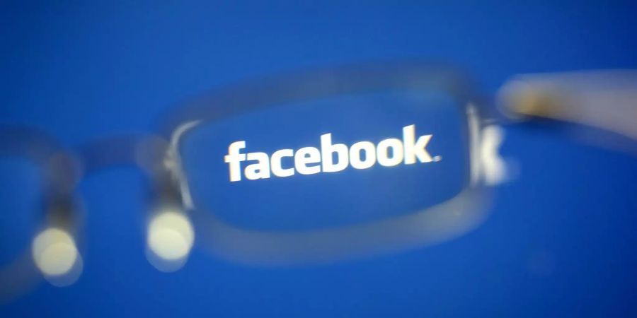 Das Logo von Facebook durch eine Brille.